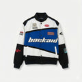 Colorblock varsity jacket with blue, black, and white panels, bold patches, and streetwear details