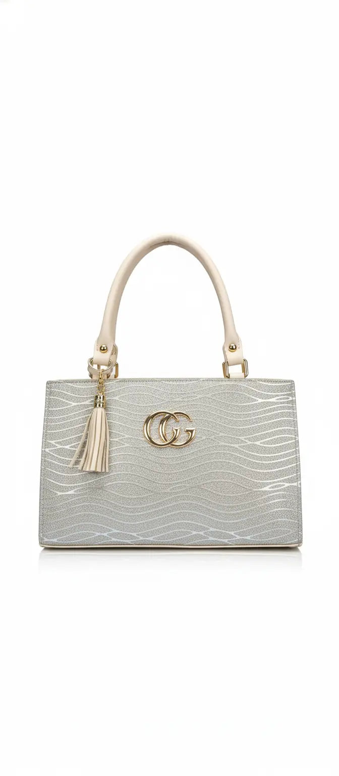 Silver structured handbag with gold accents, cream handles, tassel charm, and wavy textured design