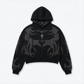 Black streetwear hoodie with bold gray abstract flame design and small cross detail on chest