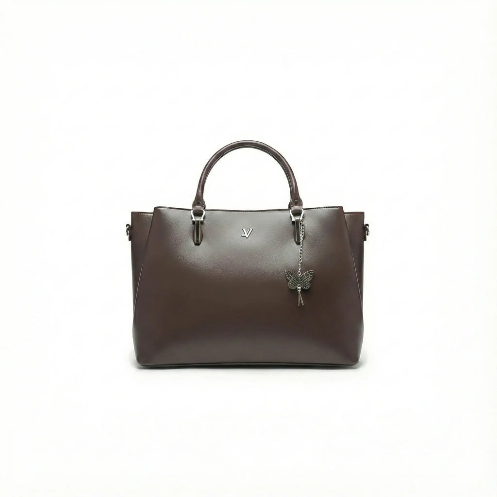 Dark brown leather handbag with top handles and butterfly charm on plain white background