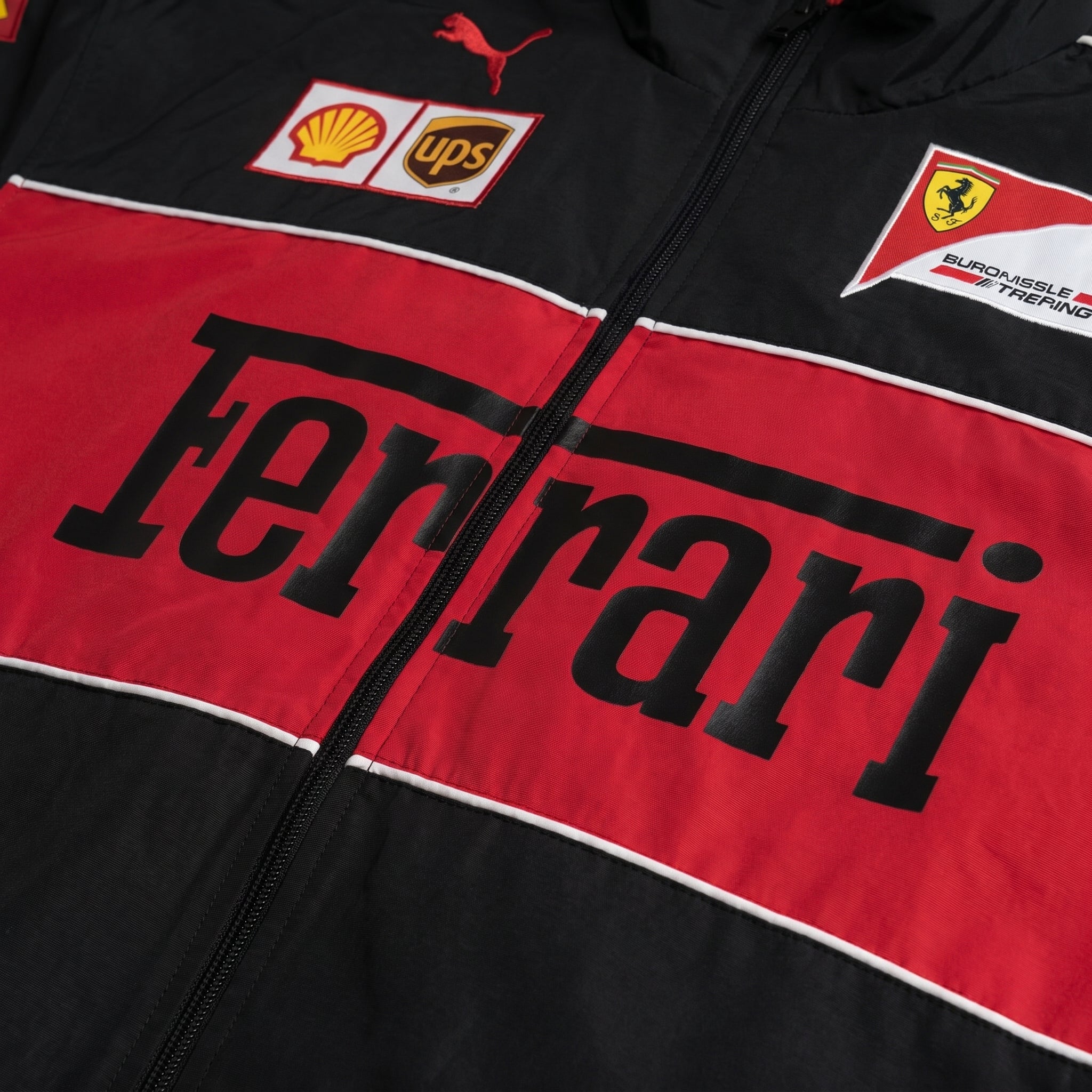 Black and red Ferrari jacket with various logos on a close-up view